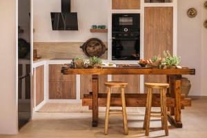 a kitchen with a wooden island with stools at Le tresor de Marie - Charming Traditional Retreat, by ZanteWize in Gaïtánion
