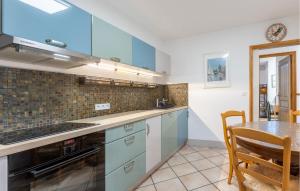 eine Küche mit blauen Schränken und einem Tisch darin in der Unterkunft Gorgeous Home In Montady in Montady