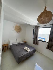 a bedroom with a bed with two towels on it at L'étoile de taghazout in Taghazout