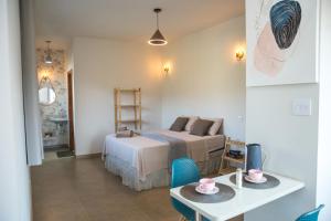 a bedroom with a bed and a table with a table sidx sidx sidx at Pousada Lapinha Da Serra 1 - Chalés Independentes e Privativos - Liberdade e Conforto na natureza in Santana do Riacho