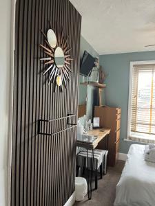 a bedroom with a bed and a desk and a table at Kelston Guest House in Weymouth