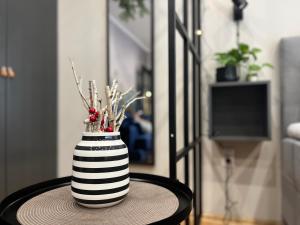 a black and white striped vase sitting on a table at Oázis Apartman in Veszprém +29 photos