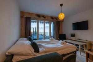 a bedroom with a large bed with a large window at Petit Nid au Chaedoz - Nendaz, 4 Vallées in Nendaz