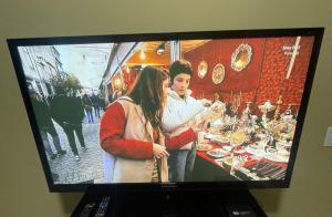 a television screen with a picture of two people at Churrasqueira e Casa privativa, Acesse os 2 quartos com 2 ar e banheiros se reservar 4 ou mais hóspedes, até 6 camas e tem pátio, roupa de cama, portão eletrônico e Desconta duração! Entrada padrão 15h adiante, inclusive à noite - Projeto Suíte Sorriso in Sorriso +12 photos