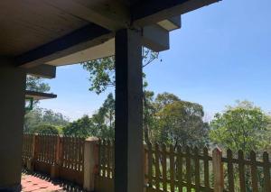 a fence in front of a wooden fence with trees at Holiday homes by Friday Retreats in Pīrmed