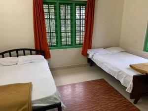 two beds in a room with green windows at Holiday homes by Friday Retreats in Pīrmed