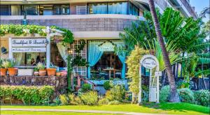 un edificio con plantas y un cartel delante de él en Hawaiian Monarch OCEAN & CANAL View - Newly Renovated - Waikiki Studio, en Honolulu