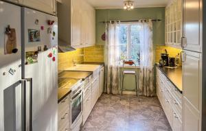 a kitchen with a white refrigerator and a sink at Nice Home In Alsterbro With Sauna in Alsterbro