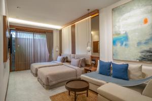 a hotel room with two beds and a couch at KammOra Living and Villas - Bali Invest Club in Canggu +159 photos