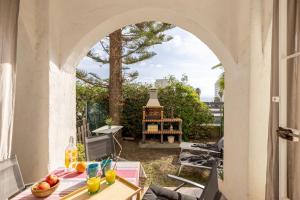 an archway over a table with drinks on a patio at Charming house next to the sea in Benalmádena