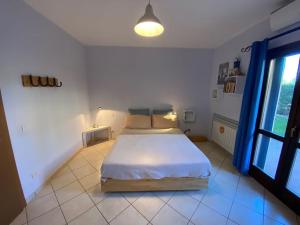 マルシリアナにあるCasa con giardino in Maremmaの白い部屋にあるベッドのある寝室
