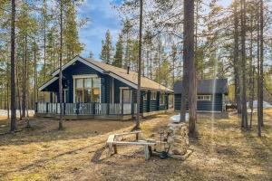 a cabin in the woods with a bench in front of it at Kiilopää Lodge Lapland Cabin in Kakslauttanen