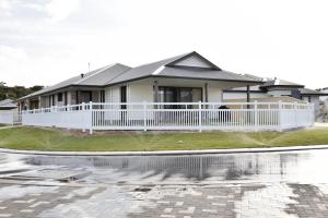 a house with a white fence and a yard at Olu managed by Sahas Homes in Dunsborough