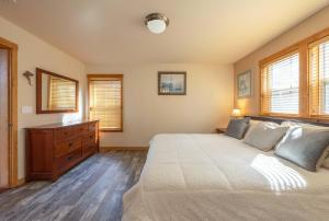 Schlafzimmer mit einem Bett, einer Kommode und Fenstern in der Unterkunft Sandbar Haven in Hood River