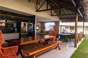 a kitchen and dining room with a wooden table and chairs at Villaggio Di Mare - até 28 pessoas in Luis Correia
