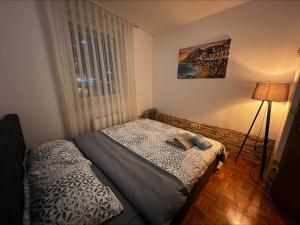 a small bedroom with a bed and a window at Sunrise Apartment in Prishtina, Kosovo in Pristina