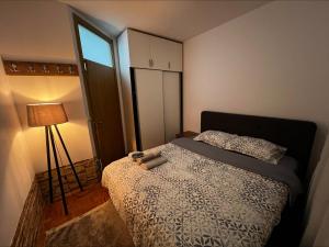 a small bedroom with a bed and a lamp at Sunrise Apartment in Prishtina, Kosovo in Pristina