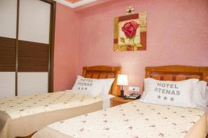 Rúm í herbergi á Hôtel Atenas