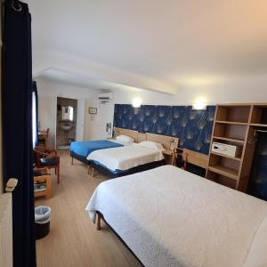 a hotel room with two beds and a desk at Hotel La Louisiane in Paris
