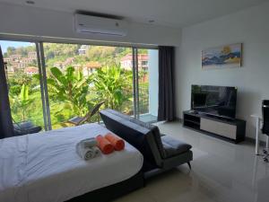 a bedroom with a bed and a large window at AtKaronWithChadaB311 in Karon Beach