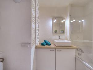 a white bathroom with a sink and a shower at Studio Soyouz Vanguard-104 by Interhome in Le Corbier