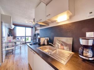 a kitchen with a sink and a mixer on a counter at Studio Soyouz Vanguard-104 by Interhome in Le Corbier