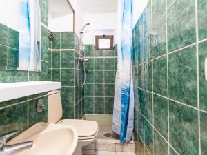 a green tiled bathroom with a toilet and a shower at Apartment The Nest by Interhome in Ventimiglia