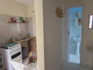 Una pequeña cocina con fregadero y estufa. en Apartamentos Veneza, en Canoa Quebrada 92 fotos más
