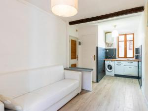 a living room with a white couch and a kitchen at Apartment The Nest by Interhome in Ventimiglia
