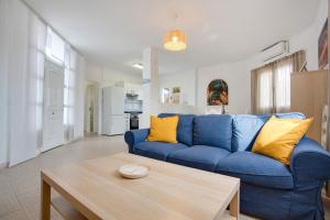 a living room with a blue couch and a table at Villa Brisa de Gairia in Antigua