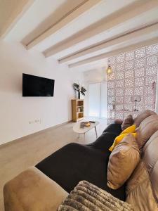 Una sala de estar con un sofá y un televisor. en Portichuelo Majuelo, en Almuñécar