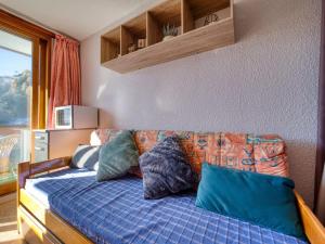 a bed with pillows on it in a room at Studio Soyouz Vanguard-102 by Interhome in Le Corbier