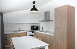 eine Küche mit einem weißen Tisch und einem weißen Kühlschrank in der Unterkunft Amazing Apartment In Marina Di Modica in Marina di Modica