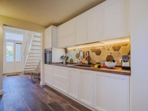 リド・ディ・カマイオーレにあるHoliday Home Rosa dei Venti by Interhomeの白いキャビネットと木製の床を備えたキッチン
