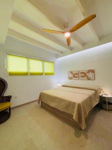 Un dormitorio con una cama y un ventilador de techo. en Portichuelo Majuelo, en Almuñécar