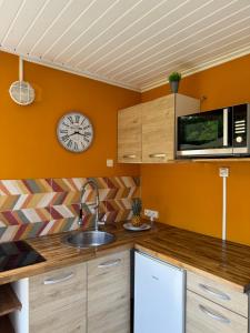a kitchen with a sink and a clock on the wall at Manbana 333 in Folle Anse