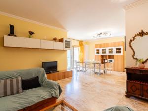 a living room with a couch and a television at Apartment le Mimose by Interhome in Taggia