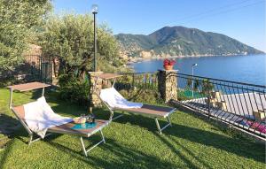 two chairs and a table on a lawn with a view of the water at Terrazza Sul Golfo Paradiso in Recco