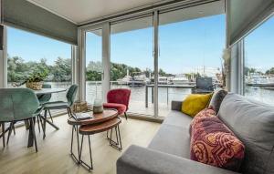 马斯特里赫特House Boat Martinique的客厅里有一张沙发、一张桌子和几把椅子