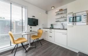 a kitchen with white cabinets and a table and chairs at House Boat Statia in Maastricht