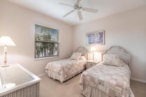 a bedroom with two beds and a ceiling fan at Marco Home - 3BR - Pet Friendly - Pool & Lanai in Marco Island +40 photos