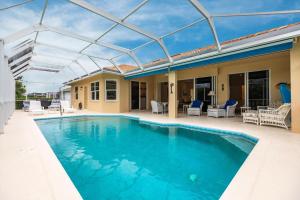 a swimming pool with a glass roof on a house at Marco Home - 3BR - Pet Friendly - Pool & Lanai in Marco Island