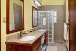 une salle de bain avec deux lavabos et une douche dans l'établissement Residences at Barrier Reef 1-3C Oceanfront 2 BR by Stay Floreo, à San Pedro