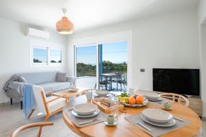 un soggiorno con un tavolo e un divano di Villa Antreas Mentoros a Karavádhos