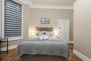 a white bedroom with a large bed with two pillows at Cozy Sunlit Studio with Kitchenette in London