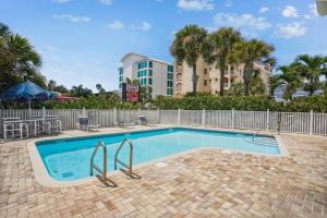 Una piscina con sillas y un edificio. en Spacious Beach Condo - Mariners Pointe, en Clearwater Beach