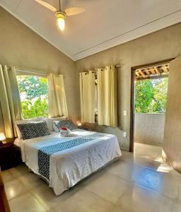 a bedroom with a large bed and a window at Jardim Secreto Guest House in Búzios