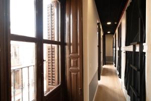 a hallway with two windows and a door at Adventure Hostel Madrid in Madrid