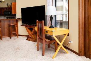 a desk with a lamp and a television in a room at Residences at Barrier Reef 3B Oceanview 2 BR by Stay Floreo in San Pedro