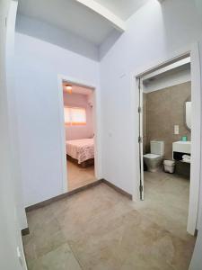 Habitación blanca con cama y baño. en Portichuelo Majuelo, en Almuñécar